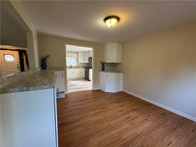 a view of a kitchen with a sink and dishwasher wooden floor