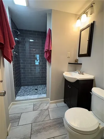 a bathroom with a sink a toilet and shower