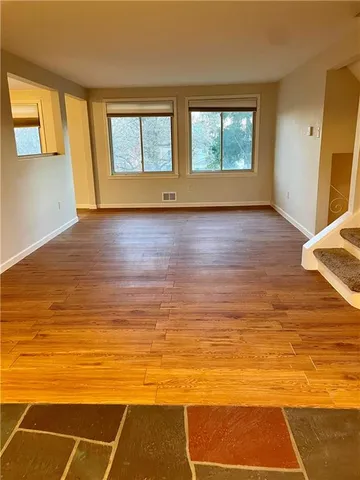 a view of room with wooden floor and windows