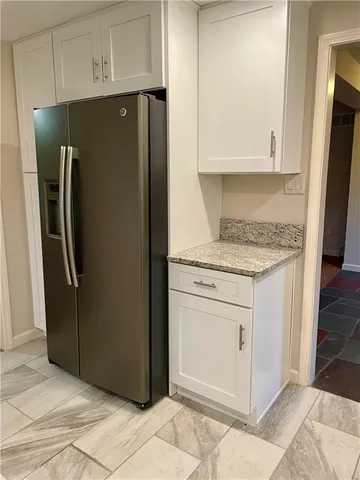 a kitchen with stainless steel appliances granite countertop a refrigerator and a stove
