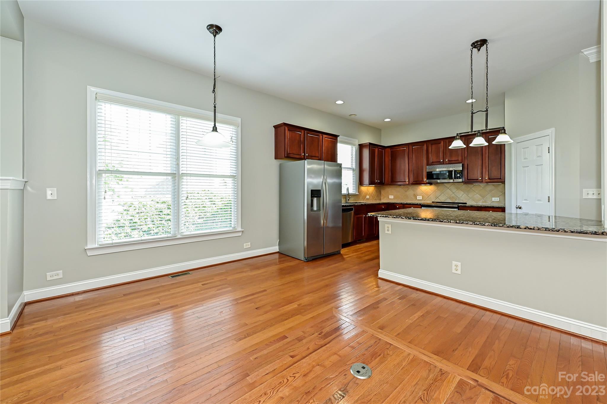 105 Mills Lane Fort Mill, SC 29708 - Photo 11 of 41 a kitchen with stainless steel appliances granite countertop a refrigerator a sink dishwasher a stove and white countertops with wooden floor