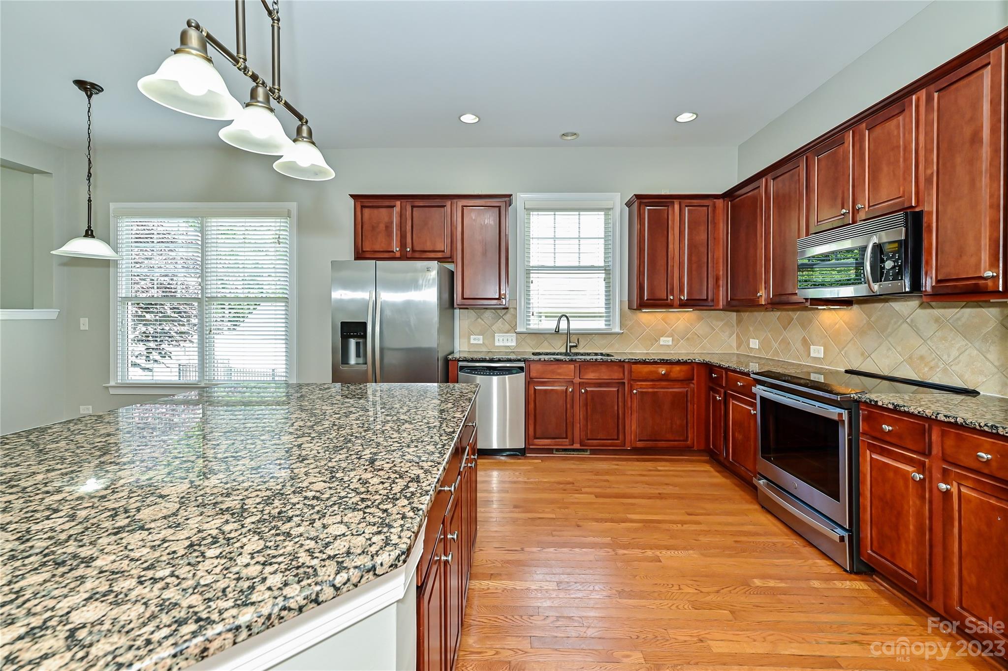 105 Mills Lane Fort Mill, SC 29708 - Photo 13 of 41 a kitchen with stainless steel appliances granite countertop wooden cabinets a stove top oven a sink and dishwasher