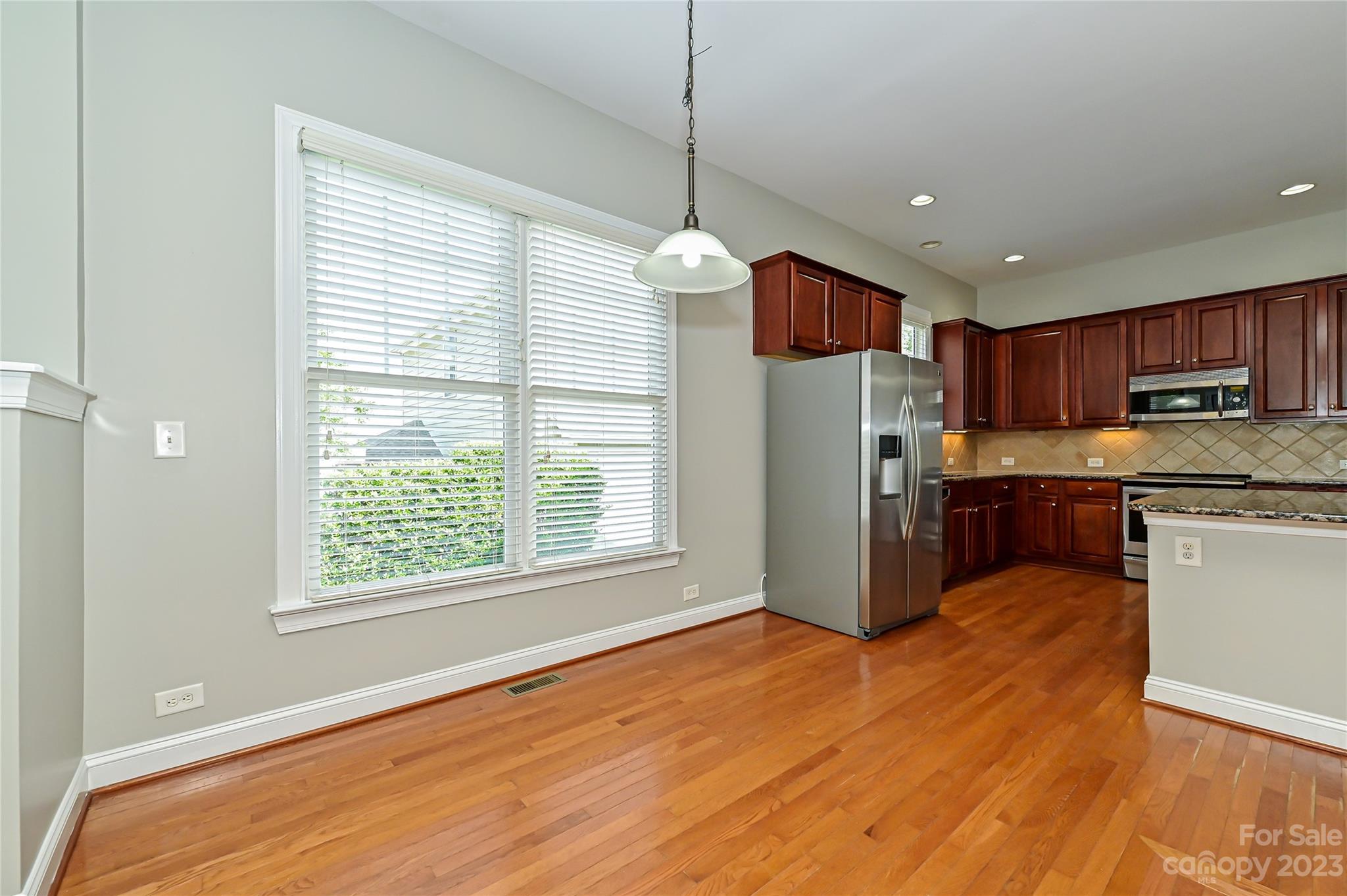 105 Mills Lane Fort Mill, SC 29708 - Photo 17 of 41 a kitchen with stainless steel appliances granite countertop a refrigerator a sink dishwasher a stove and white countertops with wooden floor