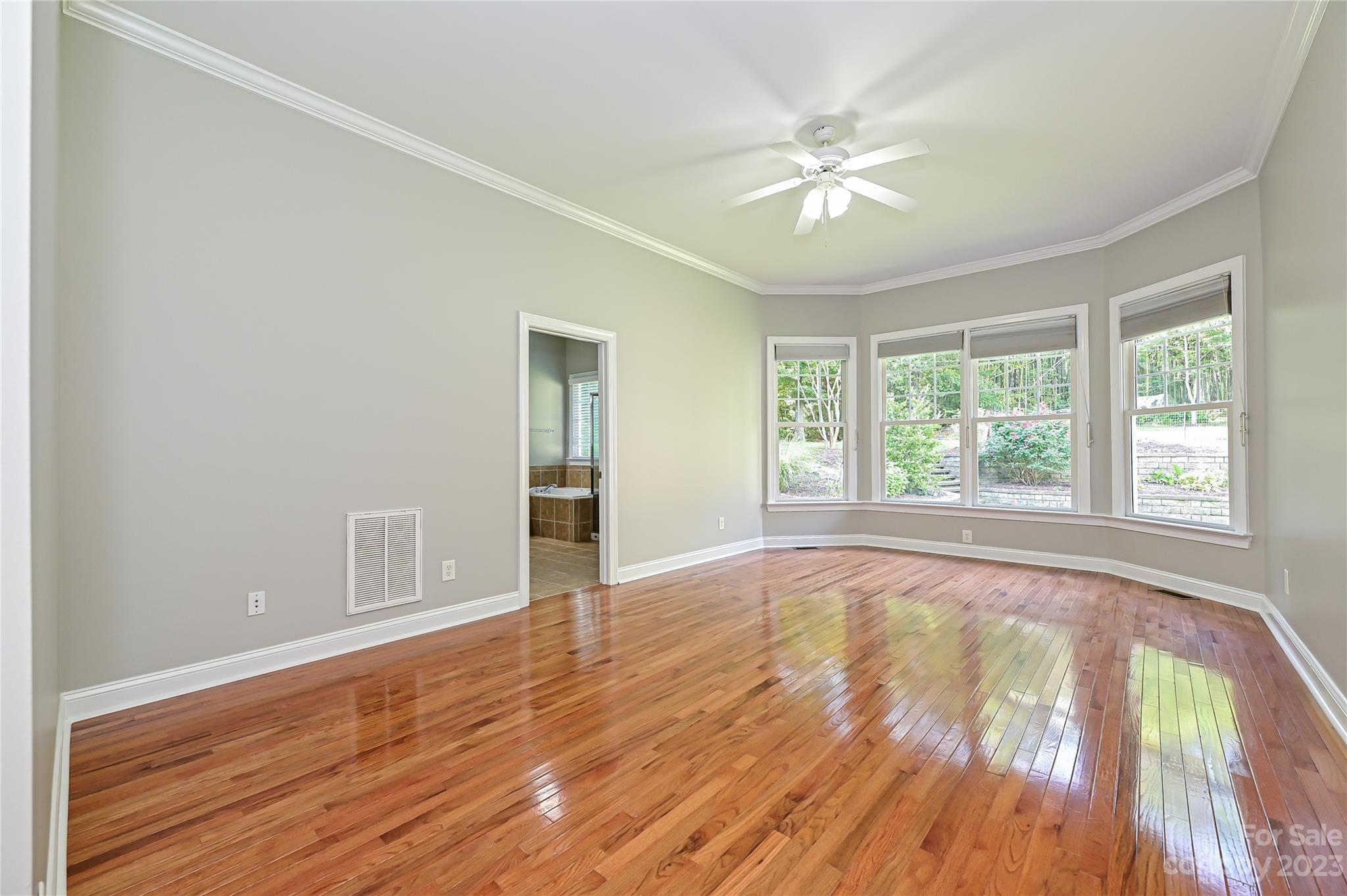 105 Mills Lane Fort Mill, SC 29708 - Photo 20 of 41 an empty room with wooden floor fan and windows