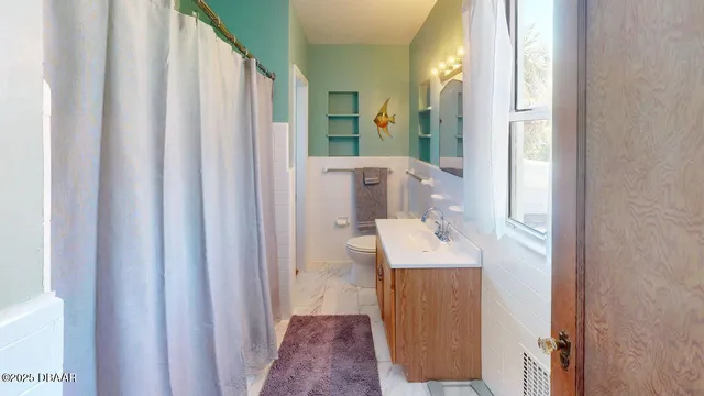 a bathroom with a sink a mirror a toilet and shower