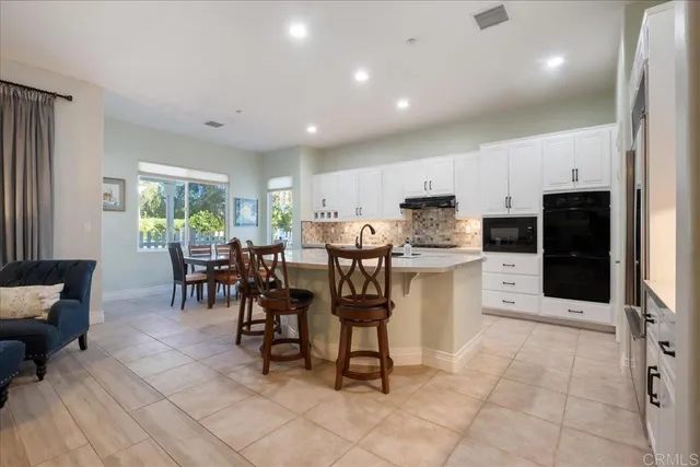 a large kitchen with granite countertop a sink and cabinets