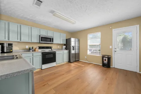 a kitchen with a refrigerator a stove top oven a sink and dishwasher
