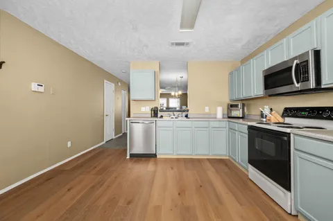a kitchen with stainless steel appliances granite countertop a stove a sink and a microwave