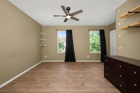 an empty room with closet and a ceiling fan