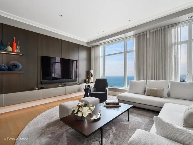 a living room with furniture flat screen tv and a large window