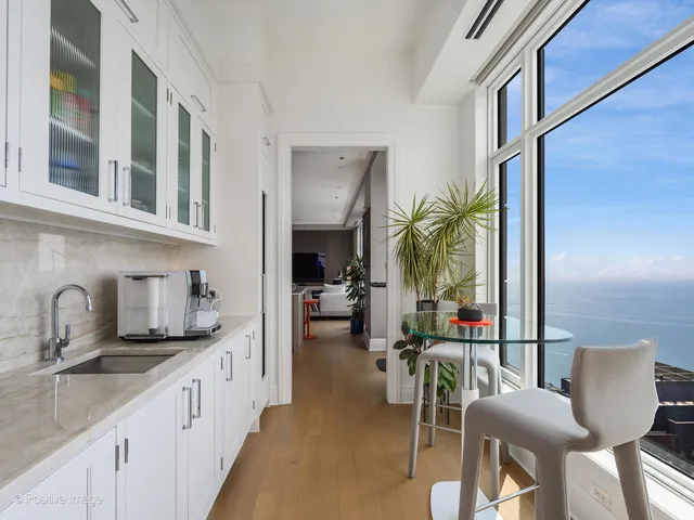 a kitchen with stainless steel appliances granite countertop sink a table and chairs