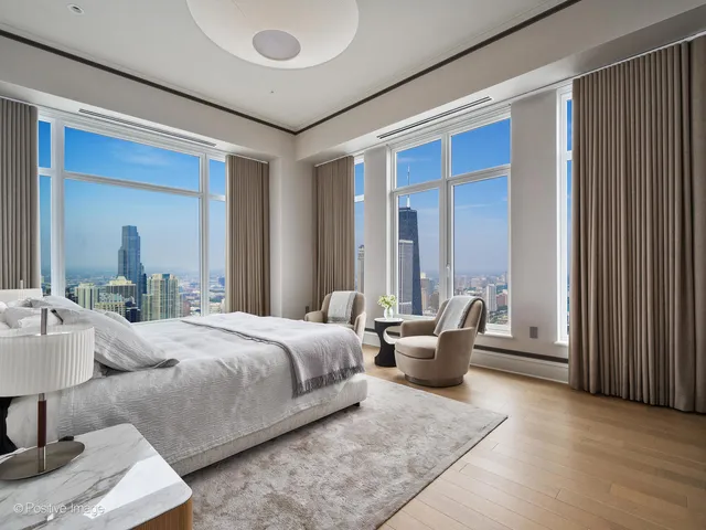 a bedroom with furniture and large windows