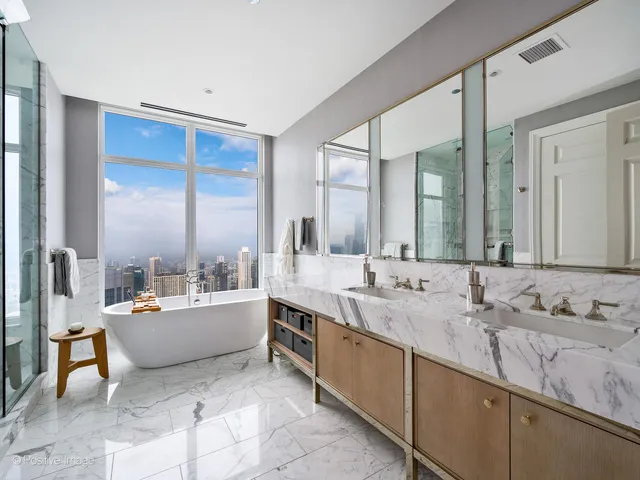 a large bathroom with a double vanity sink a mirror and a bathtub