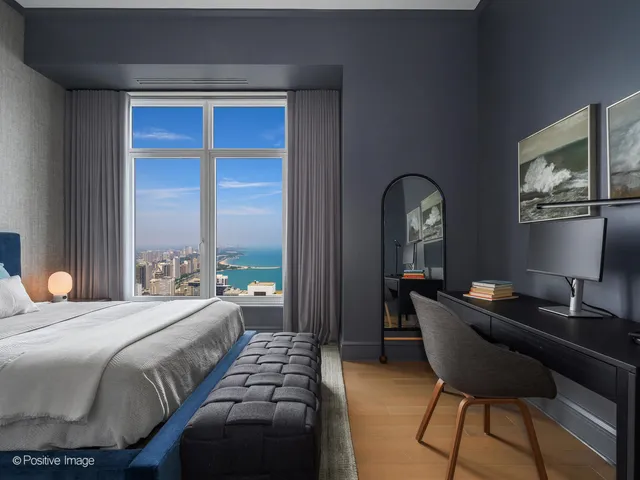 a bedroom with a bed and a potted plant on dresser