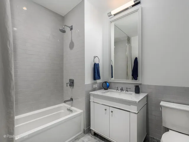 a bathroom with a sink toilet vanity and shower