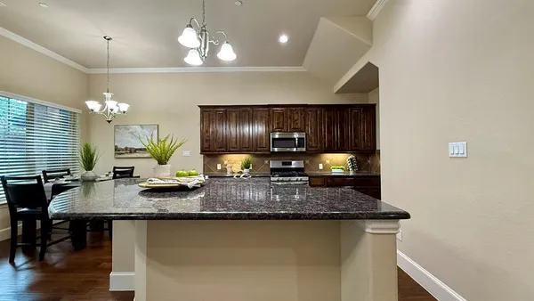 a kitchen with sink a refrigerator and chairs