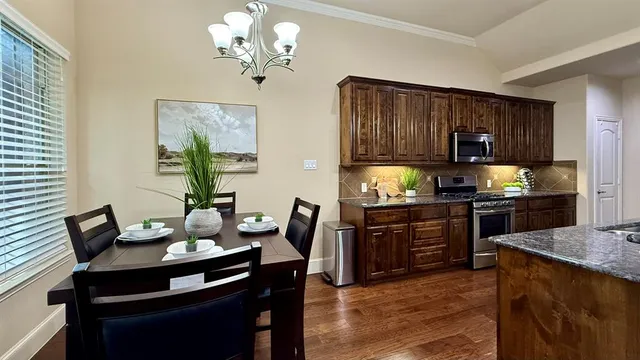 a kitchen with a stove a kitchen island a dining table and chairs