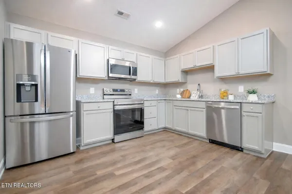 a kitchen with white cabinets stainless steel appliances and sink