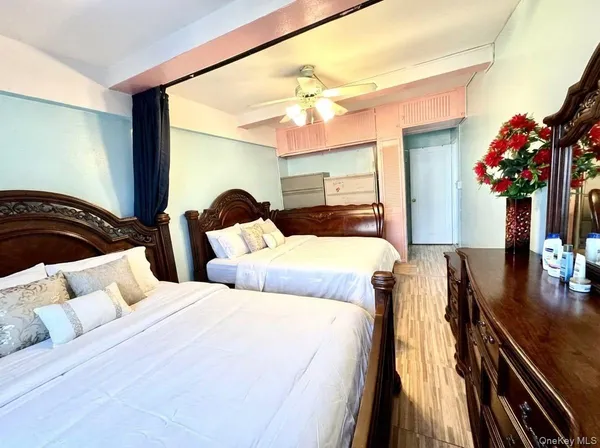 a bedroom with two beds and a potted plant