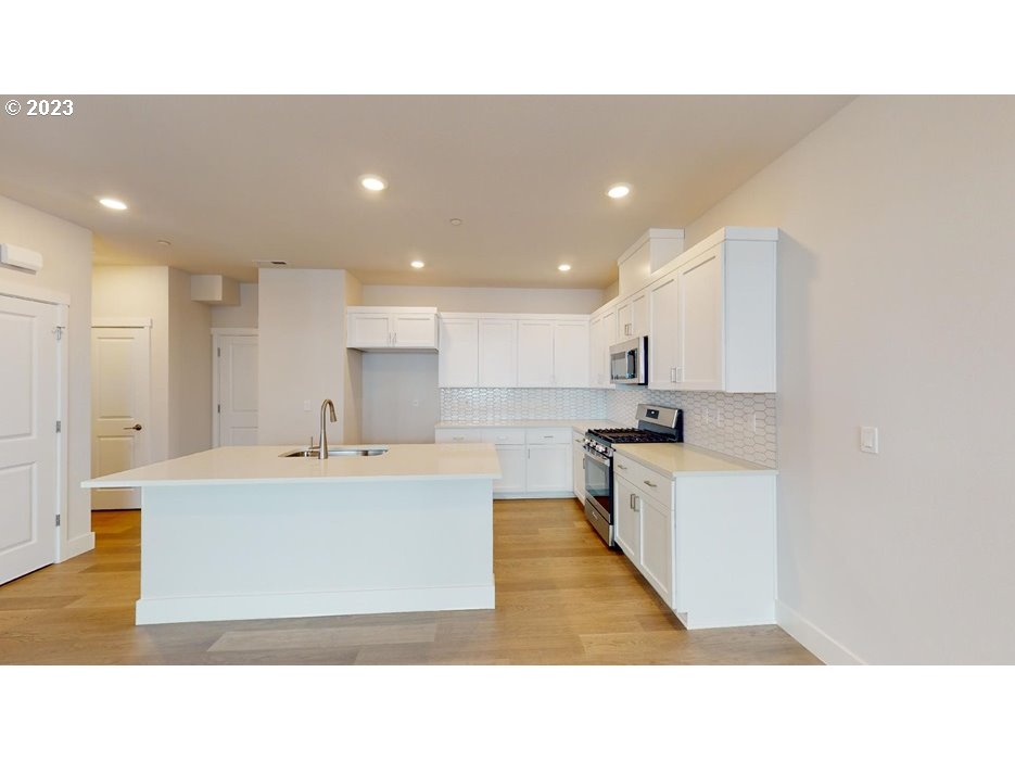 12915 Southwest Tabor Terrace Beaverton, OR 97007 - Photo 5 of 11 a open kitchen with kitchen island white cabinets and stainless steel appliances