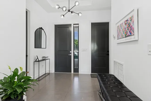 a view of a hallway with wooden floor and a bathroom