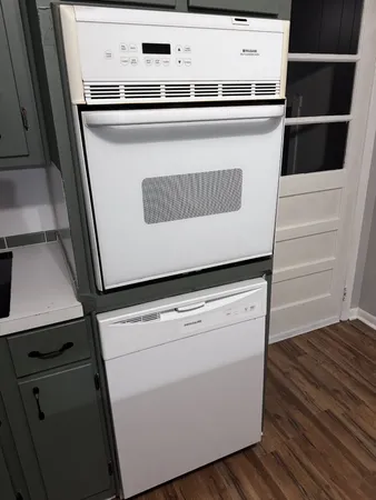 a close up view of washer and dryer with wooden floor