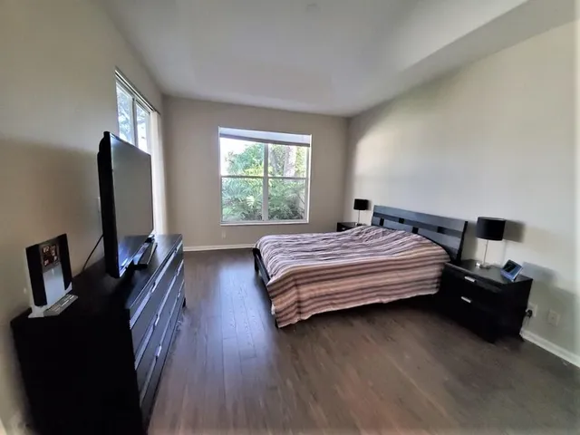 a bedroom with a bed and a flat tv screen on a dresser