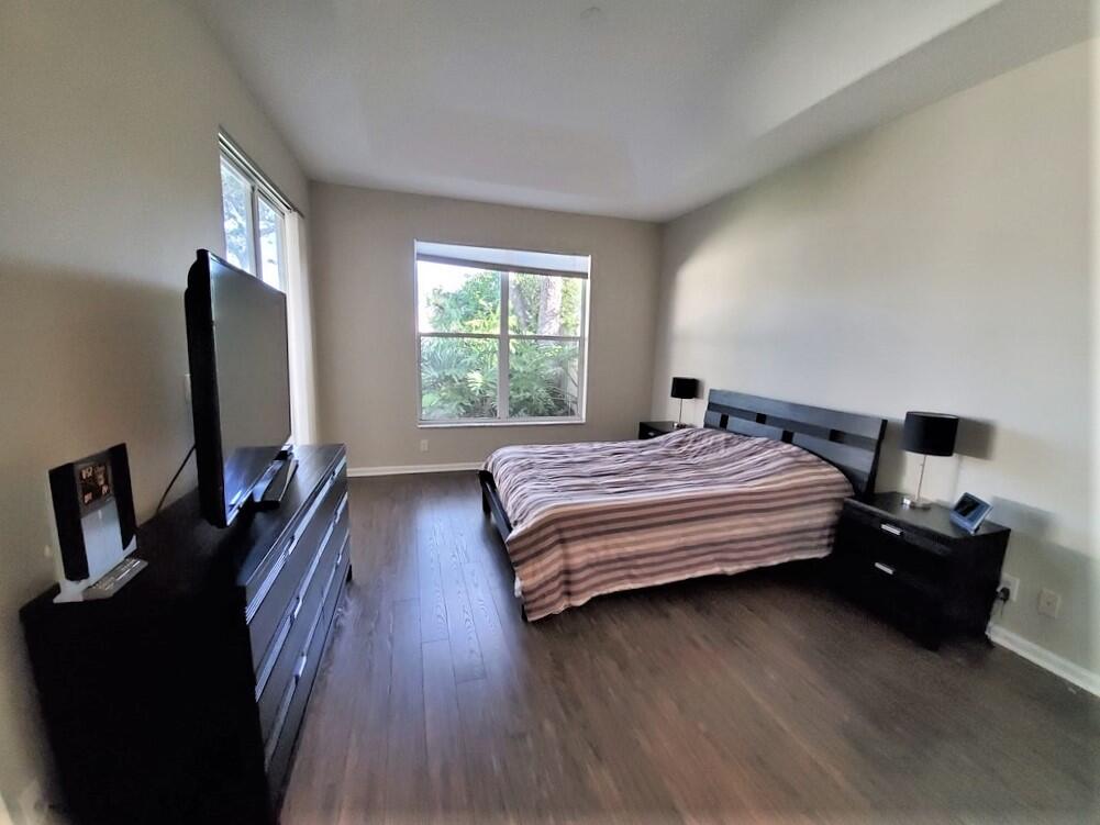 46 Pinnacle Cove Palm Beach Gardens, FL 33418 - Photo 11 of 20 a bedroom with a bed and a flat tv screen on a dresser