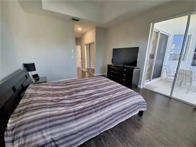 a bedroom with a bed and a flat screen tv