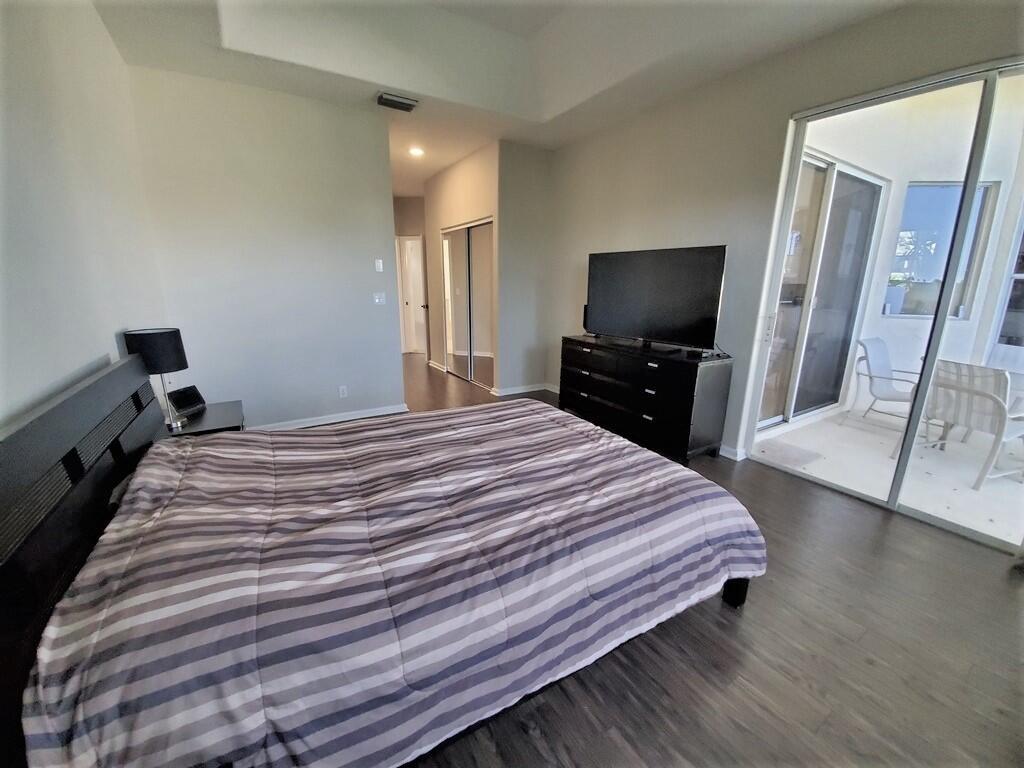 46 Pinnacle Cove Palm Beach Gardens, FL 33418 - Photo 12 of 20 a bedroom with a bed and a flat screen tv