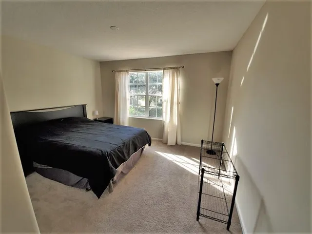 a spacious bedroom with a bed and a chair