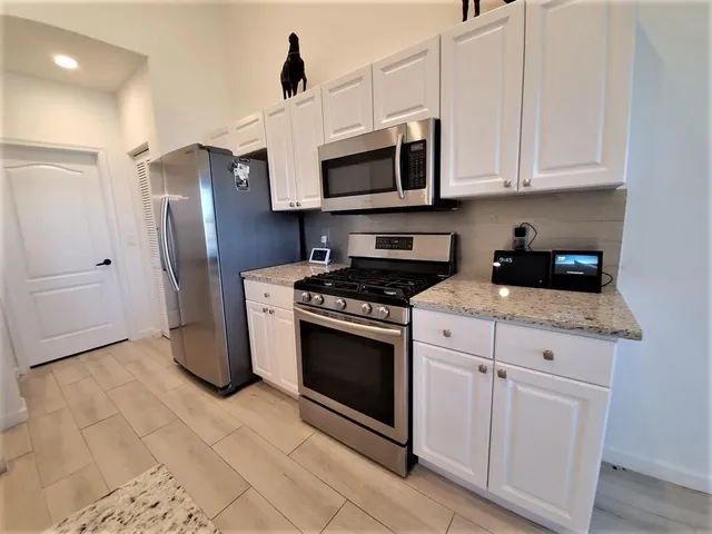 a kitchen with stainless steel appliances granite countertop a stove a microwave and a refrigerator