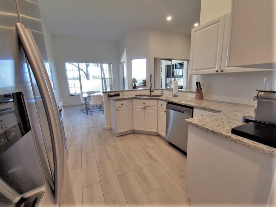 46 Pinnacle Cove Palm Beach Gardens, FL 33418 - Photo 6 of 20 a kitchen with stainless steel appliances granite countertop a sink stove and refrigerator