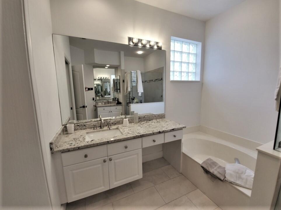 46 Pinnacle Cove Palm Beach Gardens, FL 33418 - Photo 9 of 20 a bathroom with a granite countertop sink a large mirror and a bathtub