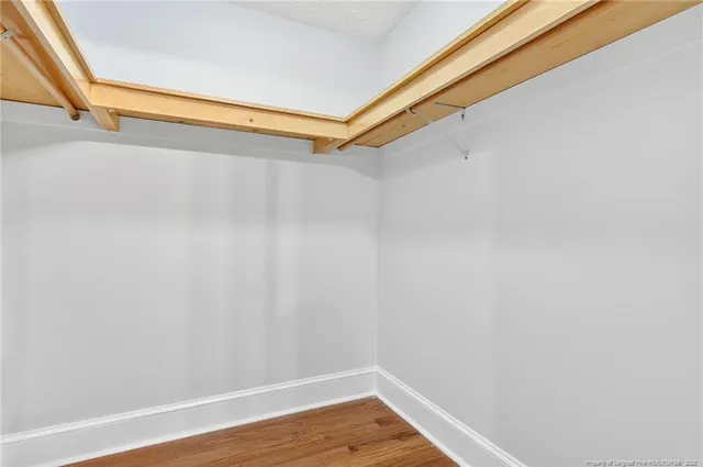 a view of walk in closet with wooden floor