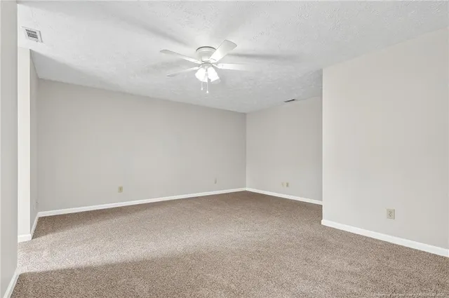 an empty room with a ceiling fan and a window