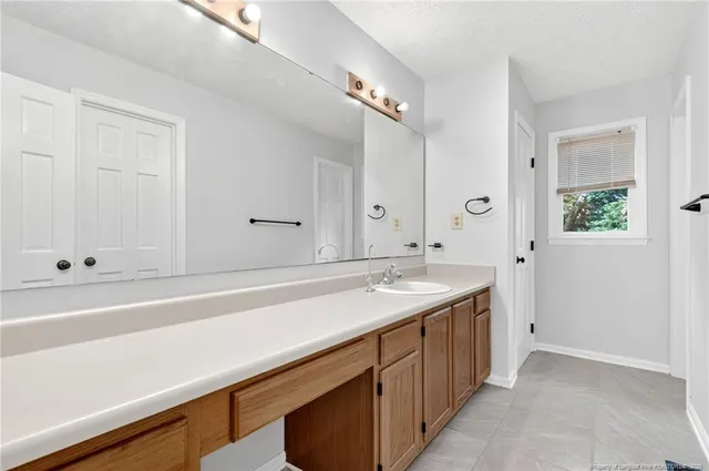 a spacious bathroom with a sink and a mirror