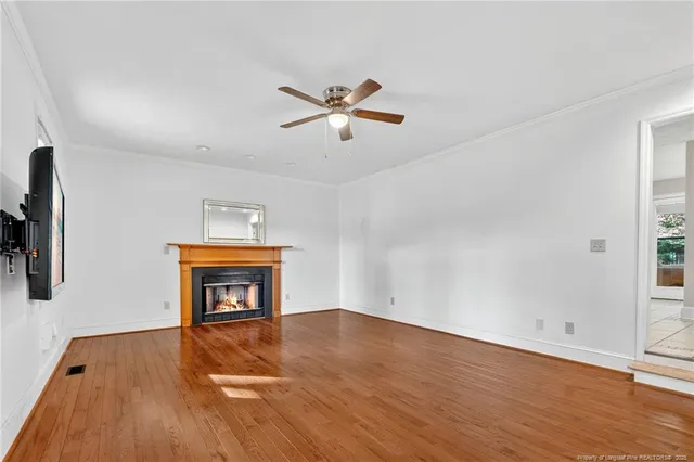 a view of empty room with a fireplace and wooden floor