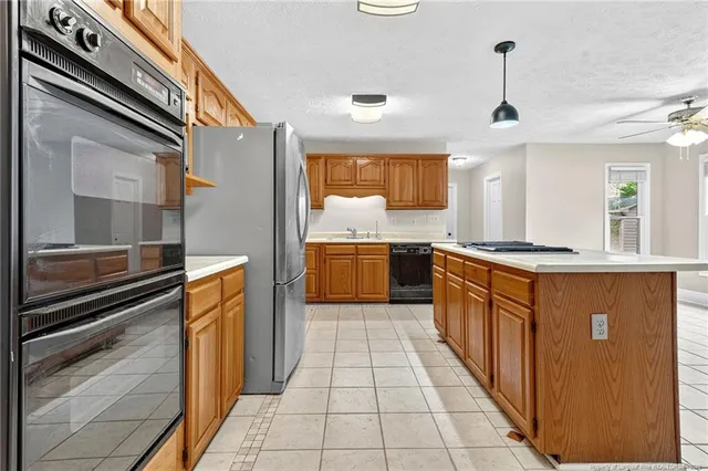 a large kitchen with stainless steel appliances granite countertop a refrigerator and a stove