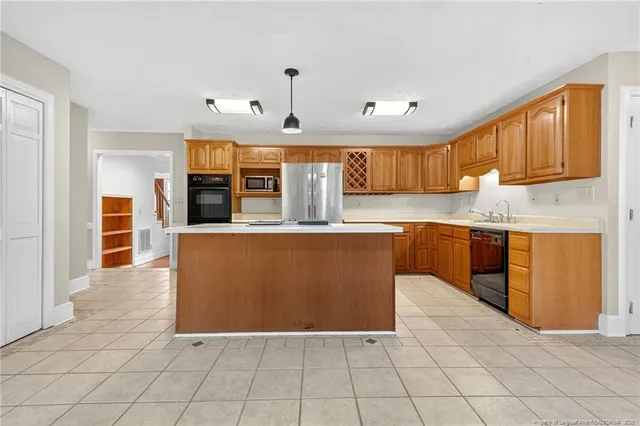 a large kitchen with stainless steel appliances granite countertop a stove a sink dishwasher and a refrigerator