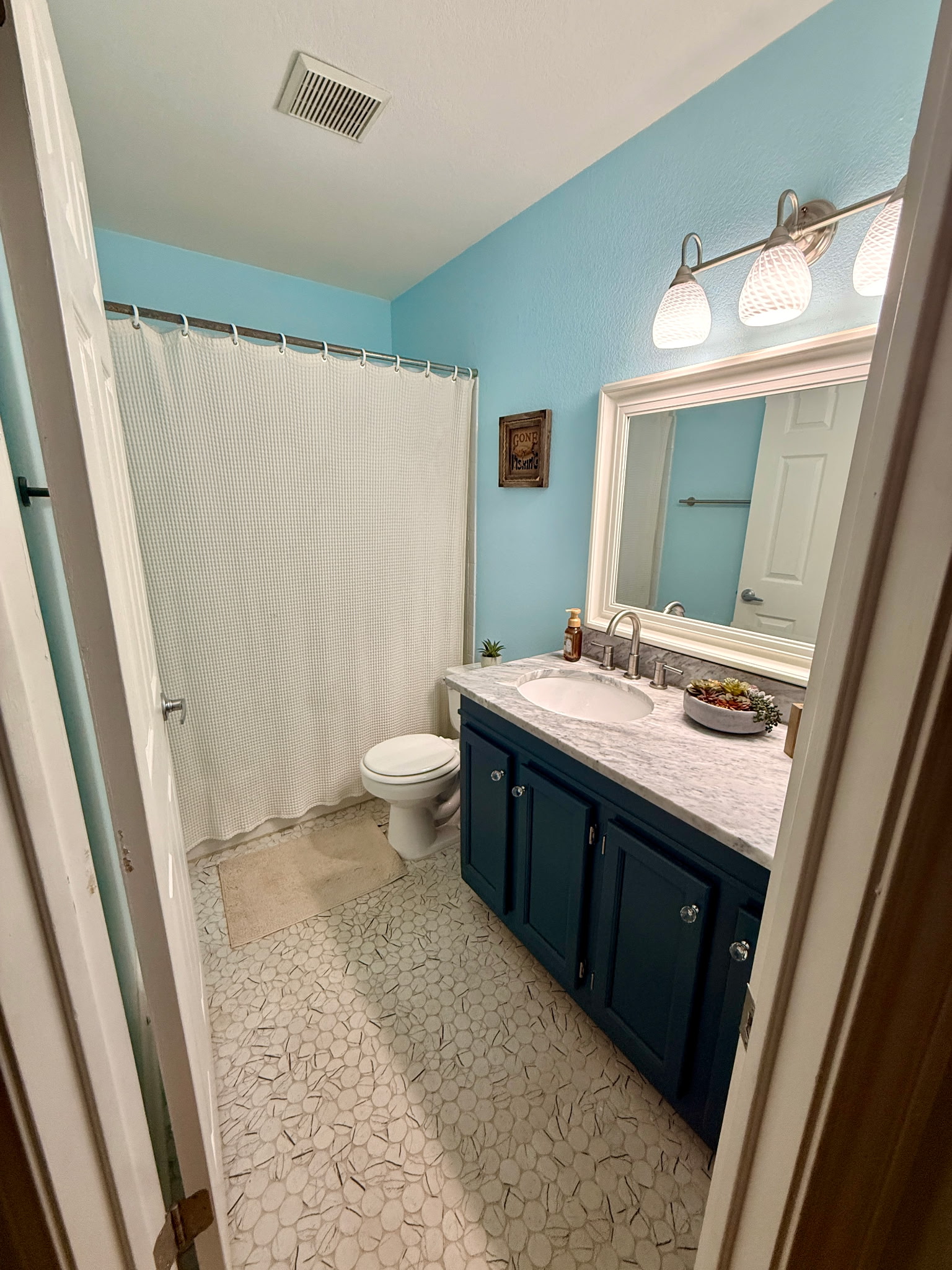 904 Double File Cove Round Rock, TX 78665 - Photo 25 of 25 Textured tile flooring and a stone-topped vanity define this refreshing bathroom space.