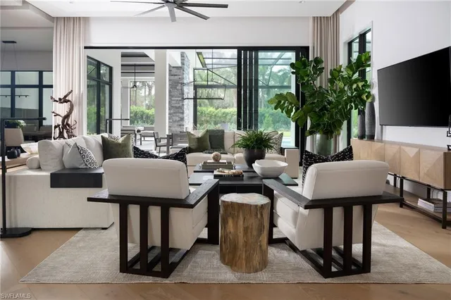 a living room with patio furniture and a potted plant
