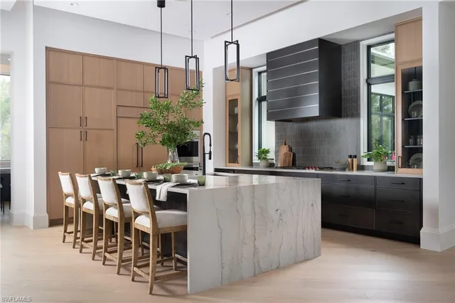 a kitchen with kitchen island granite countertop a table chairs and a large window