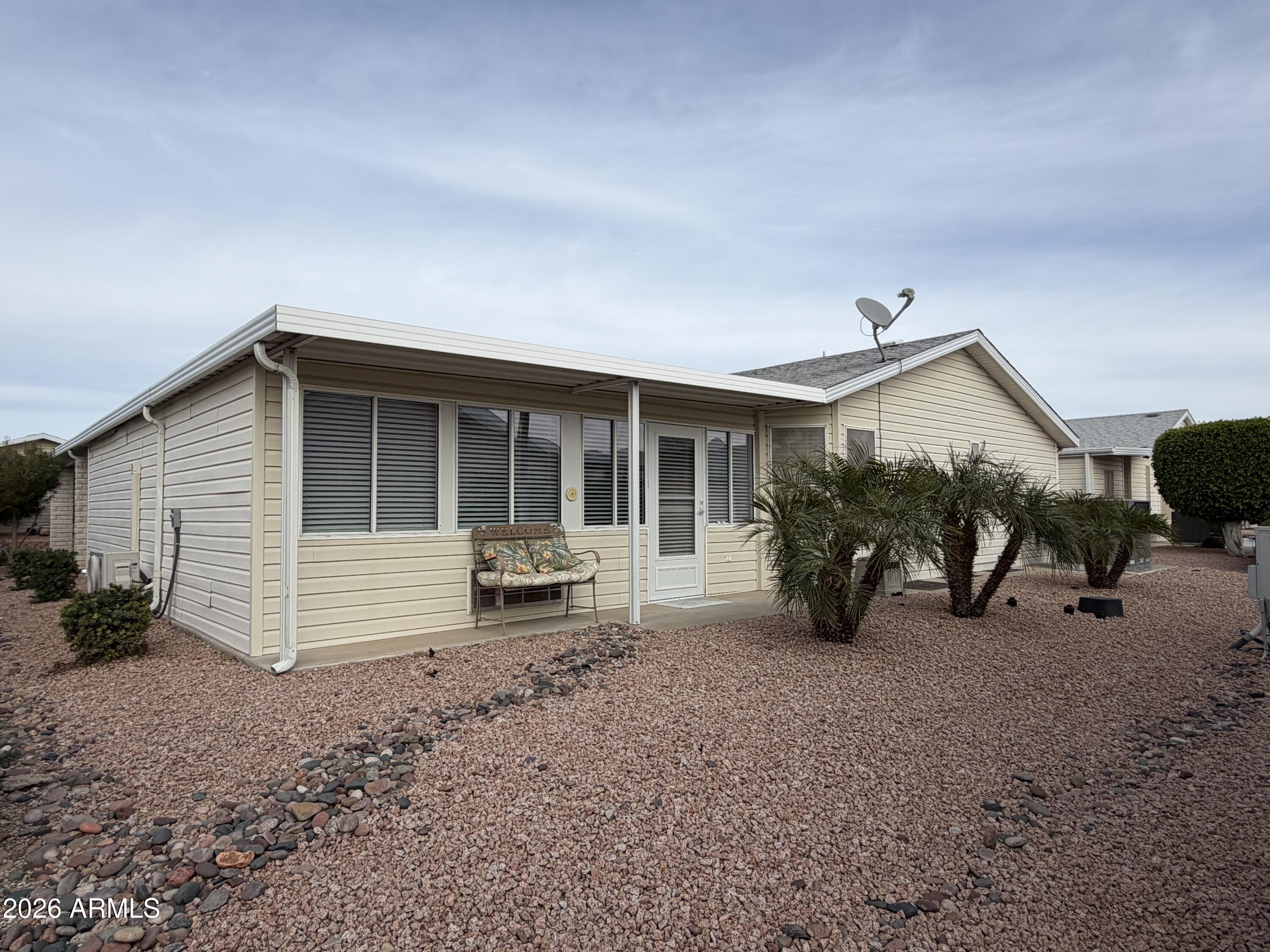 215 North Power Road, Unit 384 Mesa, AZ 85205 - Photo 24 of 27 a view of a house with a patio and a yard