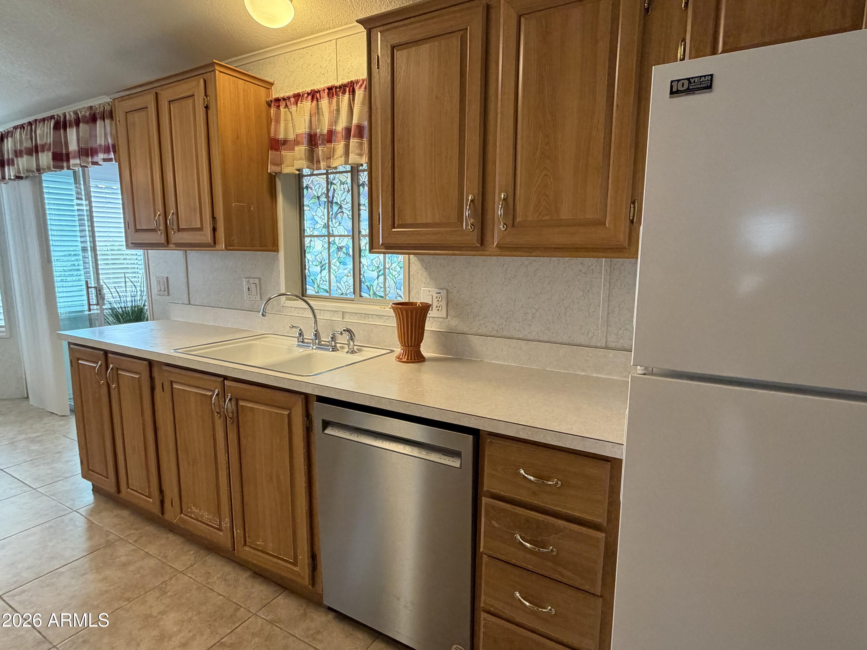 215 North Power Road, Unit 384 Mesa, AZ 85205 - Photo 7 of 27 a kitchen with a sink and a refrigerator