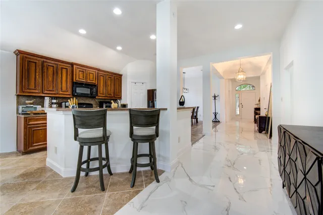 a view of kitchen with sink microwave and cabinets