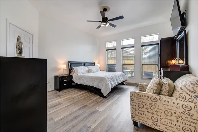 a bedroom with a bed a couch and a large window