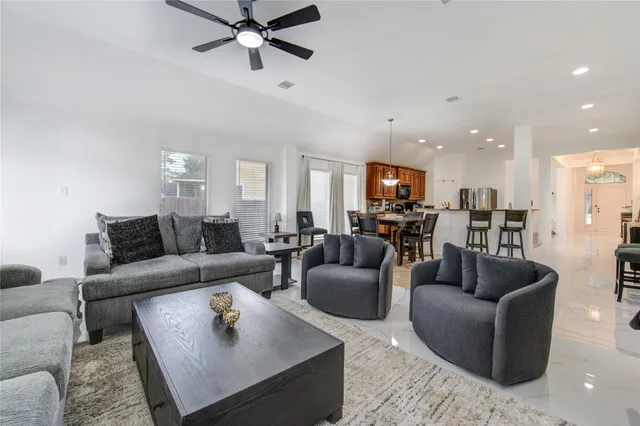 a view of a dining room and livingroom with furniture wooden floor a chandelier