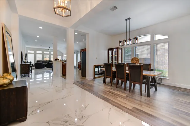 a view of a dining room and livingroom with furniture wooden floor a chandelier