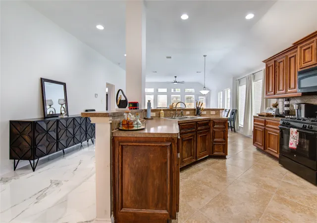 a kitchen with stainless steel appliances granite countertop a stove top oven a sink a counter space and cabinets
